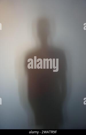 Mann-Silhouette hinter Milchglas Stockfoto