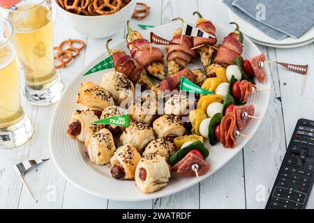 Nahaufnahme einer Platte voller Vorspeisen am Spieltag, serviert mit Bier. Stockfoto