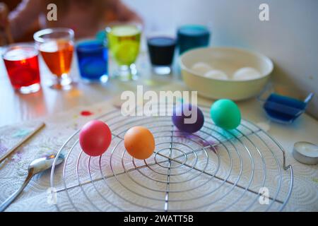 Mit Lebensmittelfärbung Ostereier zu Hause färben. Ich malte bunte Eier für die Osterjagd. Bereit für die Osterfeier. Familientraditionen. Stockfoto