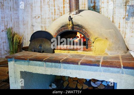 Weiß bemalter Holzofen mit Feuer darin Stockfoto