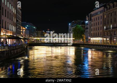 Genf, Schweiz 8. September 2023: Nächtlicher Blick auf den Fluss mit wunderschönen Reflexionen der Stadt Genf in der Schweiz Stockfoto