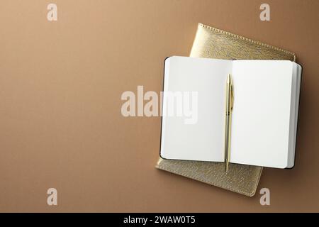 Notizbücher und Stift auf hellbraunem Hintergrund, Draufsicht. Leerzeichen für Text Stockfoto