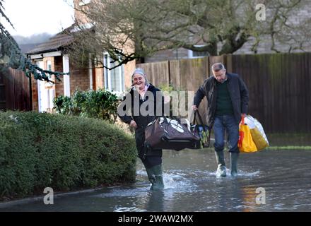 Brampton, Großbritannien. Januar 2024. Die Bewohner schnappen sich einige Taschen mit Notvorräten und verlassen ihr Haus, während das Hochwasser weiter steigt. Hochwasserwarnmeldungen bleiben bestehen, da die Gewässer im Osten Englands nach Sturm Henk weiter steigen. Die wichtigsten Flüsse der Fluss Great Ouse und der Fluss Nene sind über ihre Ufer geplatzt und in die umliegende Landschaft gespült, und mit voll ausgelasteten Abflüssen werden sie wieder in Wohngebieten eingesetzt. Quelle: SOPA Images Limited/Alamy Live News Stockfoto