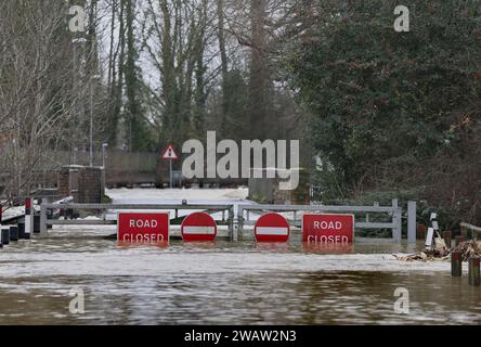 St Neots, Großbritannien. Januar 2024. An den Toren sind Verkehrsschilder mit der Aufschrift „Straße geschlossen“ und „keine Einfahrt“ angebracht, die den Verkehr auf der überfluteten Straße verhindern, wenn der Fluss Great Ouse seine Ufer platzt. Hochwasserwarnmeldungen bleiben bestehen, da die Gewässer im Osten Englands nach Sturm Henk weiter steigen. Die wichtigsten Flüsse der Fluss Great Ouse und der Fluss Nene sind über ihre Ufer geplatzt und in die umliegende Landschaft gespült, und mit voll ausgelasteten Abflüssen werden sie wieder in Wohngebieten eingesetzt. Quelle: SOPA Images Limited/Alamy Live News Stockfoto