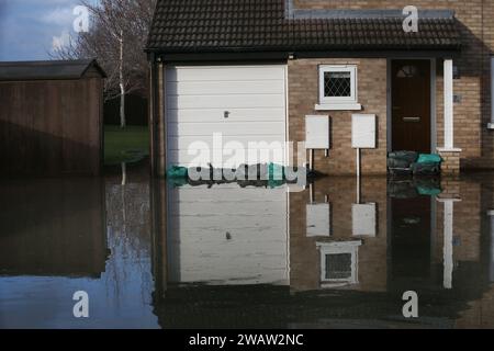 Brampton, Großbritannien. Januar 2024. Ein Haus in der Hansell Road schützt ihre Garage und Haustür mit Sandsäcken, während das Hochwasser weiter steigt. Hochwasserwarnmeldungen bleiben bestehen, da die Gewässer im Osten Englands nach Sturm Henk weiter steigen. Die wichtigsten Flüsse der Fluss Great Ouse und der Fluss Nene sind über ihre Ufer geplatzt und in die umliegende Landschaft gespült, und mit voll ausgelasteten Abflüssen werden sie wieder in Wohngebieten eingesetzt. Quelle: SOPA Images Limited/Alamy Live News Stockfoto