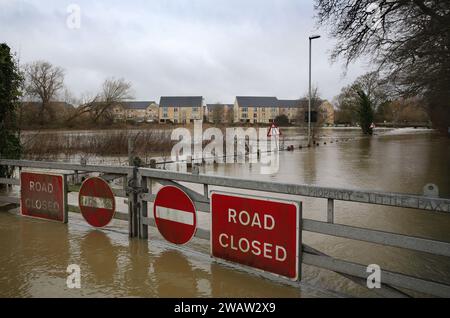 St Neots, Großbritannien. Januar 2024. An den Toren sind Verkehrsschilder mit der Aufschrift „Straße geschlossen“ und „keine Einfahrt“ angebracht, die den Verkehr auf der überfluteten Straße verhindern, wenn der Fluss Great Ouse seine Ufer platzt. Hochwasserwarnmeldungen bleiben bestehen, da die Gewässer im Osten Englands nach Sturm Henk weiter steigen. Die wichtigsten Flüsse der Fluss Great Ouse und der Fluss Nene sind über ihre Ufer geplatzt und in die umliegende Landschaft gespült, und mit voll ausgelasteten Abflüssen werden sie wieder in Wohngebieten eingesetzt. (Foto von Martin Pope/SOPA Images/SIPA USA) Credit: SIPA USA/Alamy Live News Stockfoto