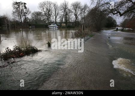 Grantchester, Großbritannien. Januar 2024. Der Fluss Great Ouse stürzt über den Weg auf Felder und Parkanlagen, während der Fluss Granchester seine Ufer sprengt. Hochwasserwarnmeldungen bleiben bestehen, da die Gewässer im Osten Englands nach Sturm Henk weiter steigen. Die wichtigsten Flüsse der Fluss Great Ouse und der Fluss Nene sind über ihre Ufer geplatzt und in die umliegende Landschaft gespült, und mit voll ausgelasteten Abflüssen werden sie wieder in Wohngebieten eingesetzt. (Foto von Martin Pope/SOPA Images/SIPA USA) Credit: SIPA USA/Alamy Live News Stockfoto