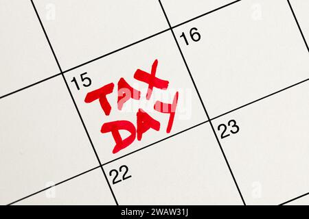 15. April in Rot als Steuertag auf einem weißen Kalender zur Erinnerung an die Einkommensteuer hervorgehoben, flach, Ansicht von oben nach unten, Handschrift mit roter Markierung Stockfoto