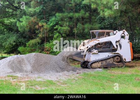 Während der Bauarbeiten bewegt sich der Minilader von Bobcat mit zerquetschtem Steinkies Stockfoto