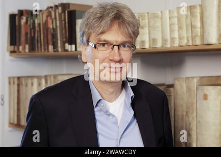 Weimar, Deutschland. Dezember 2023. Reinhard Laube, Direktor der Herzogin Anna Amalia Bibliothek, steht neben Büchern in der Bibliothek. (Zu dpa: "Anna Amalia Direktorin: Klimawandel auch eine Bedrohung für Bibliotheken"). Quelle: Bodo Schackow/dpa/Alamy Live News Stockfoto