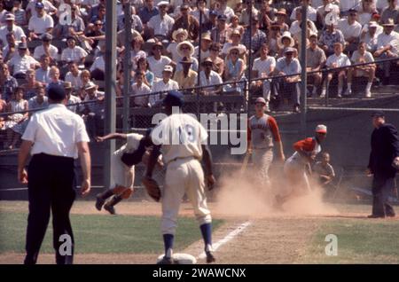 LOS ANGELES, KALIFORNIEN – 9. JULI: Vada Pinson #28 der Cincinnati Reds erzielt am 9. Juli 1961 im Los Angeles Memorial Coliseum in Los Angeles (Kalifornien) auf der Sacrafice Fly von Teamkollege Gene Freese #12 (nicht im Bild). Der dritte Baseman der Dodgers ist Jim Gilliam #19 und der Schiedsrichter Stan Landes. (Foto von Hy Peskin) *** örtlicher Bildtitel *** Vada Pinson;Jim Gilliam;Stan Landes Stockfoto