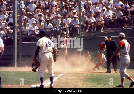 LOS ANGELES, KALIFORNIEN – 9. JULI: Vada Pinson #28 der Cincinnati Reds erzielt am 9. Juli 1961 im Los Angeles Memorial Coliseum in Los Angeles (Kalifornien) auf der Sacrafice Fly von Teamkollege Gene Freese #12 (nicht im Bild). Der dritte Baseman der Dodgers ist Jim Gilliam #19. (Foto von Hy Peskin) *** örtlicher Bildtitel *** Vada Pinson;Jim Gilliam Stockfoto