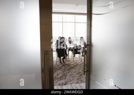 Ein vielfältiges junges Business-Team sitzt am Tisch im Besprechungsraum Stockfoto
