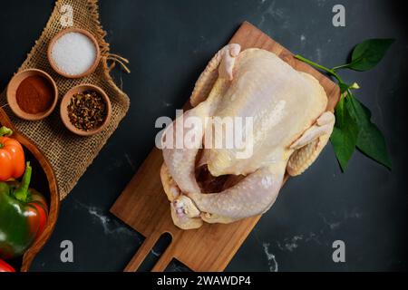 Rohes Hühnchen wird auf dem Schneidebrett präsentiert. Stockfoto