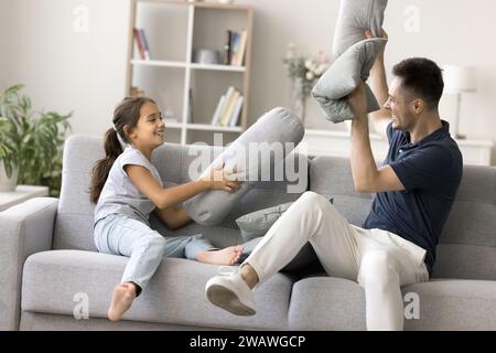 Glücklicher, aufgeregter junger Vater und energiegeladenes Mädchen, das Spaß hat Stockfoto