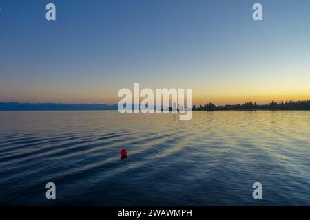 Farbenfroher Sonnenuntergang auf dem Meer. Bergsee in den Strahlen der orangen Sonne. Kirgisistan, Issyk-Kul-See. Natürlicher Hintergrund. Querformat Stockfoto