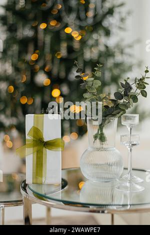 Stilvolle gewickelte weihnachtsgeschenke mit Band auf dem Tisch auf dem Hintergrund des dekorierten weihnachtsbaums mit Vintage-Kugeln, rustikalem Kamin und festlichem Stockfoto