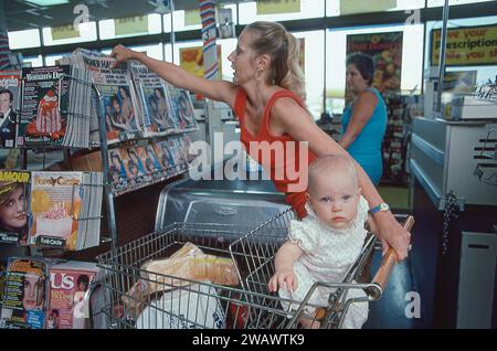 Eine Mutter greift nach einer Kopie des Star-Magazins vom 21. August 1982, während sie an der Kasse in einem Supermarkt sitzt. In einem Key Food Store in Brooklyn, New York. Stockfoto