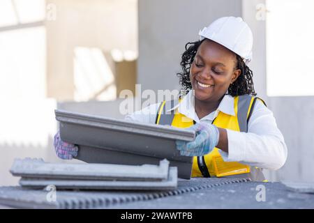 Glückliche schwarze afrikanische arbeitende Frauen Arbeiter genießen harte Arbeit für intelligente gesunde und gute Wohlfahrt Arbeitspflege und Sicherheit auf der Baustelle. Stockfoto