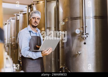 Winzer professionelle Arbeit in modernen großen Weingut Fabrik Alkohol Alkohol Getränke Industrie Qualitätskontrolle und Gärungsmonitor Vintage Farbe zu Stockfoto