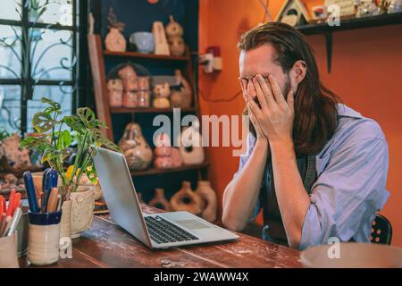 Keramikkünstler Handwerkskunst Besitzer kleiner Unternehmen scheitern an Stressausdruck durch schlechte Nachrichten, Bankrott und Schuldenprobleme Stockfoto