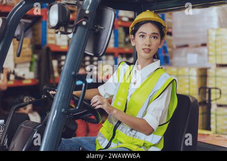 Lagerarbeiter, asiatische junge arbeitende Frauen arbeiten hart an der Fracht, die Gütercontainer mit Gabelstaplerwagen beladen Stockfoto