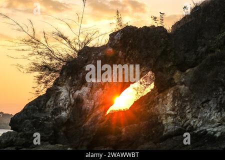 Untergehende Sonne in einem Bogen aus Kalksteinen am Meer. Stockfoto