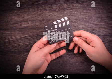 Hand-Halten-Filmklapper auf dunklem Hintergrund Stockfoto