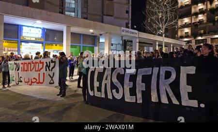 Linke israelische Aktivisten halten ein Banner mit der Aufschrift "Waffenruhe" und rufen Slogans, während sie sich zu einem Antikriegsprotest versammeln, der zu einem Waffenstillstand und einer diplomatischen Lösung für den andauernden Israel-Hamas-Krieg am 6. Januar 2024 in Jerusalem aufruft. Israel Stockfoto