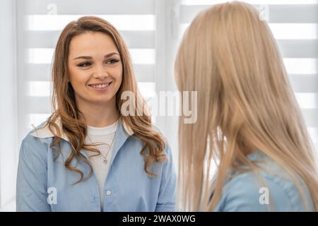 Exzellenz durch Pflege: Der Patient berät einen professionellen Kosmetikologen in einer Schönheitsklinik, in der die Bedeutung der Hautpflege hervorgehoben wird. Stockfoto