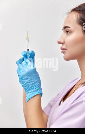 Frau Ärztin in blauen Handschuhen mit Spritze zur Injektion Stockfoto