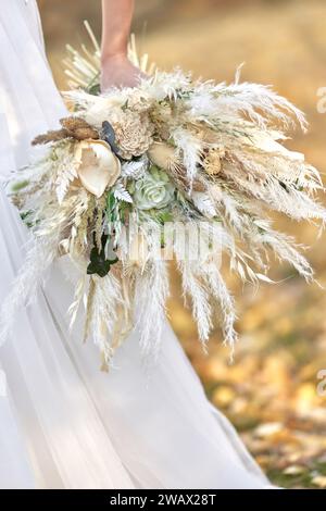 Hände der Braut, die einen wunderschönen Herbststrauß im Freien hält Stockfoto