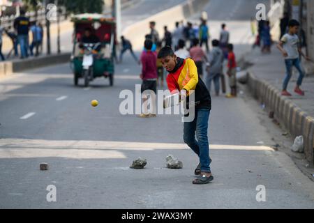 Dhaka, Bangladesch. Januar 2024. Kinder spielen am Wahltag auf einer leeren Straße Cricket. Quelle: SOPA Images Limited/Alamy Live News Stockfoto