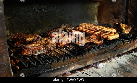 Lamm und Fleisch über offenem Feuer in einer Estancia in Patagonien kochen Stockfoto