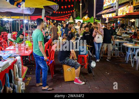 Ein Straßenmusiker in der Jalan Alor Food Street, Kuala Lumpur, Malaysia Stockfoto
