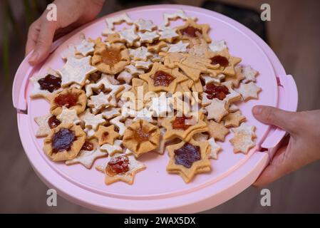 Hand hält einen Haufen gebackener Sterne und Superhelden, handgemachte Kekse Stockfoto