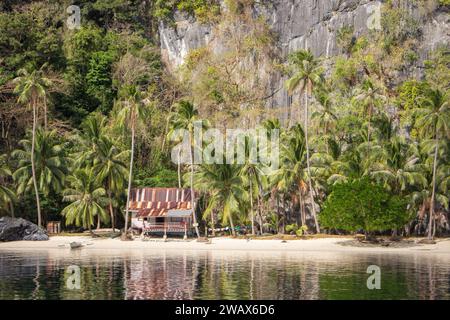 Tropische Hütte an der Meeresküste. Bambushütte am Sandstrand unter Palmen. Ökotourismus-Konzept. Entspannen Sie sich und reisen Sie in Asien. Hütte im Dschungel. Stockfoto