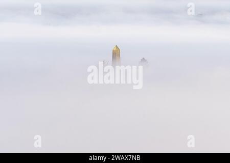 Killearn, Stirling, Schottland, Großbritannien. Januar 2024. UK Weather - eine wunderschöne Morgenwolkenumkehr über dem Dorf Stirling Killearn, von den Campsie Fells in Schottland aus gesehen. Die Spitze des Buchanan Monuments, ein 103 Fuß großer Obelisk aus lokalem weißem Mühlstein, der dem Gedenken an den Historiker und Gelehrten George Buchanan (1506–1582) gewidmet ist, der im Dorf geboren wurde und über dem Nebel zeigt Credit: Kay Roxby/Alamy Live News Stockfoto