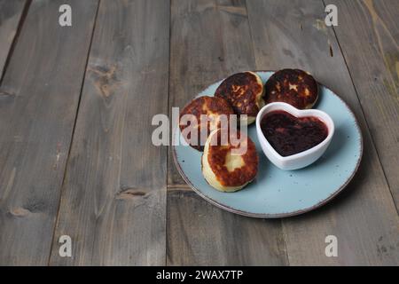 Käsekuchen auf einem Teller. Frühstück für zwei Personen auf grauem Hintergrund mit Platz für Text im Kopierbereich. Vegetarische Hüttenkäse. Stockfoto