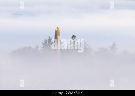 Killearn, Stirling, Schottland, Großbritannien - 7 Januar 2024 - Wetter in Großbritannien - eine wunderschöne Morgenwolke über dem Dorf Killearn von den Campsie Fells in Schottland aus gesehen. Die Spitze des Buchanan Monuments, ein 103 Fuß großer Obelisk aus lokalem weißem Mühlsteinfutter, der dem Gedenken an den Historiker und Gelehrten George Buchanan (1506–1582) gewidmet ist, der im Dorf geboren wurde und über dem Nebel zeigt Stockfoto