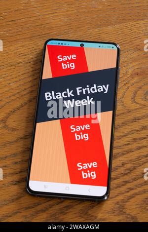 Black Friday Week – Verkaufsereignis Ende November – mit Werbebanner und -Seite aus der Amazon Shopping App auf einem Smartphone-Bildschirm, Großbritannien Stockfoto