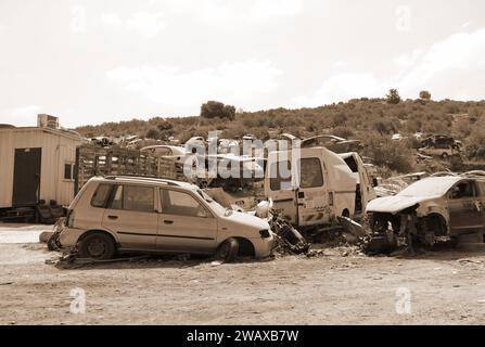 Schrottplatz für Autos. Ein Haufen von weggeworfenen Autos auf dem Schrottplatz. Israel. Palästina. Barta. Sepia-Effekt Stockfoto