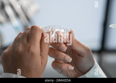Der Zahnarzt hält den Mundschutz vorsichtig in den Händen, bereitet sich auf den Eingriff vor und demonstriert seine Anpassungsfähigkeit an die höchsten Standards von Stockfoto