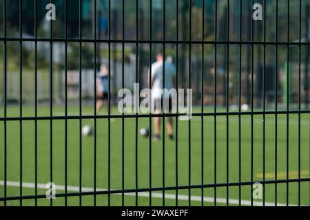 Helsinki / Finnland - 28. SEPTEMBER 2023: Zwei unscharfe Silhouetten erwachsener Männer, die auf dem Spielfeld Fußball spielen. Stockfoto