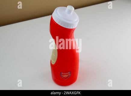 Dublin, Irland - 3. Januar 2024: Ein Foto einer roten Wasserflasche mit dem Markenzeichen Arsenal auf einem weißen Schreibtisch. Stockfoto