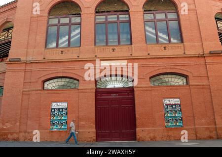 Ein Mann läuft an der Stierkampfarena La Malagueta vorbei, Malagas sechseckagonförmiger Terrakotta-farbiger Stierkampfarena im Malagueta-Viertel. Spanien, Costa del Sol Stockfoto