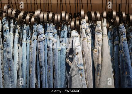 Viele blaue Jeans hängen auf einem Regal. Einkaufen, Verkaufen Stockfoto