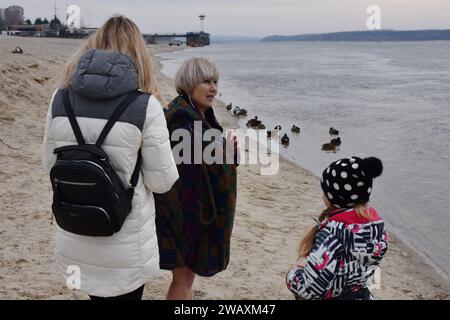 Eine ältere Frau bereitet sich darauf vor, während der Epiphanienfeier in kaltes Wasser des Flusses Dnipro zu tauchen. Erstmals seit 1917 wird am 6. Januar die Epiphanie gefeiert, die das traditionelle Datum des 19. Januar ersetzt. Die Ukraine hat traditionell den Julianischen Kalender verwendet, der auch von Russland verwendet wird, wo Epiphanien am 19. Januar fällt. In einem weiteren Wechsel von Russland markiert es nun die Epiphanik nach dem westlichen - oder gregorianischen - Kalender. Epiphanik ist einer der wichtigsten religiösen Feiertage im orthodoxen Kalender. Stockfoto