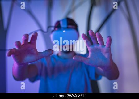 Zwei junge Männer, Besucher des Naturkundemuseums, die neue Technologien in der Ausstellung einsetzen und Virtual-Reality-Headsets platzieren. Stockfoto