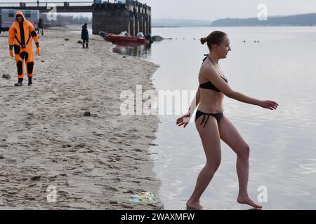 Eine Frau bereitet sich darauf vor, während der Epiphanienfeier in kaltes Wasser des Flusses Dnipro zu tauchen. Erstmals seit 1917 wird am 6. Januar die Epiphanie gefeiert, die das traditionelle Datum des 19. Januar ersetzt. Die Ukraine hat traditionell den Julianischen Kalender verwendet, der auch von Russland verwendet wird, wo Epiphanien am 19. Januar fällt. In einem weiteren Wechsel von Russland markiert es nun die Epiphanik nach dem westlichen - oder gregorianischen - Kalender. Epiphanik ist einer der wichtigsten religiösen Feiertage im orthodoxen Kalender. (Foto: Andriy Andriyenko/SOPA Images/SIPA USA) Stockfoto